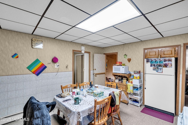 dining space with a paneled ceiling and baseboard heating