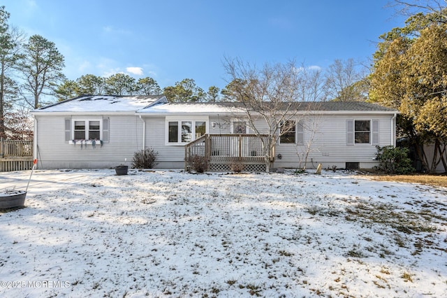 snow covered back of property featuring a wooden deck