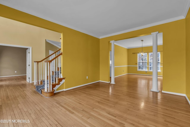 empty room featuring hardwood / wood-style flooring, ornamental molding, and decorative columns