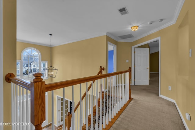 corridor with ornamental molding, light colored carpet, and an inviting chandelier