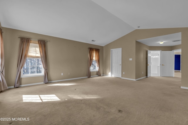 carpeted spare room with vaulted ceiling and a wealth of natural light