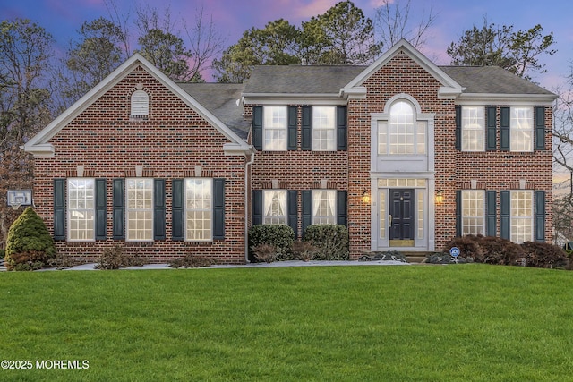 colonial inspired home with a lawn