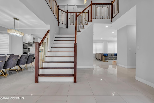 stairs with tile patterned flooring and ornamental molding