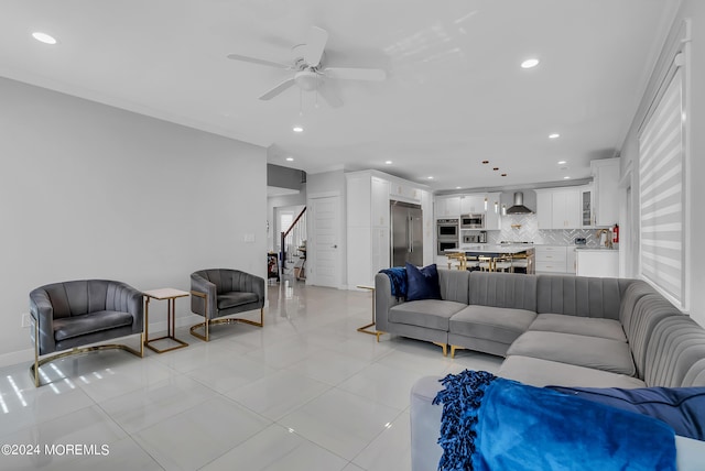 tiled living room featuring ceiling fan and ornamental molding