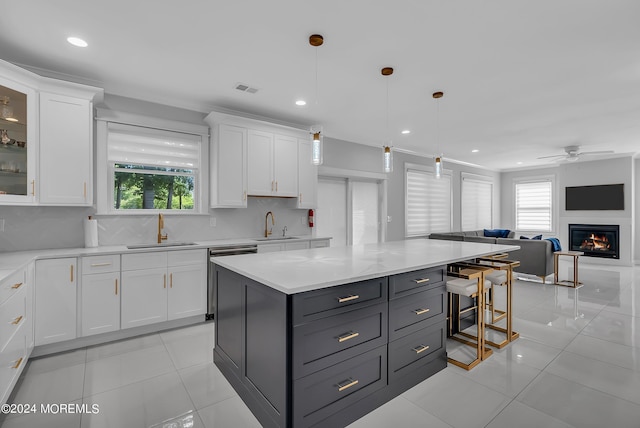 kitchen featuring hanging light fixtures, white cabinetry, sink, and tasteful backsplash