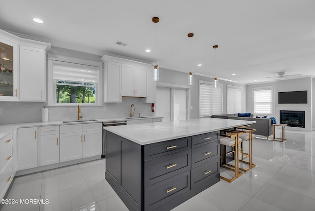 kitchen featuring white cabinetry, decorative backsplash, sink, and hanging light fixtures