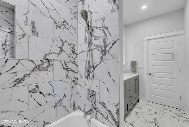 bathroom featuring tiled shower / bath and vanity