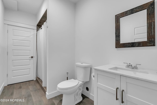 bathroom with wood-type flooring, a shower with shower curtain, vanity, and toilet