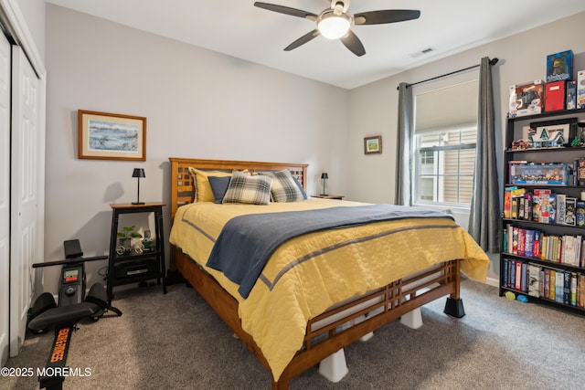 bedroom with dark colored carpet, ceiling fan, and a closet