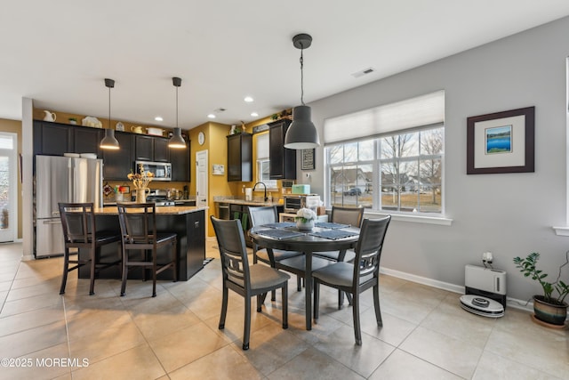 dining area featuring sink and light tile patterned floors