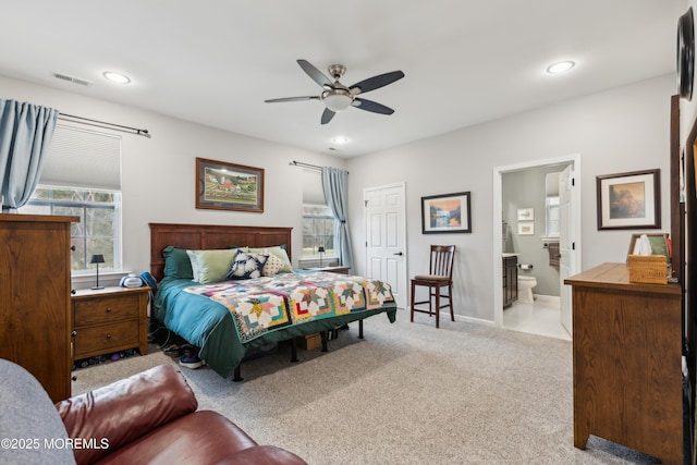 bedroom featuring ceiling fan, connected bathroom, and light carpet