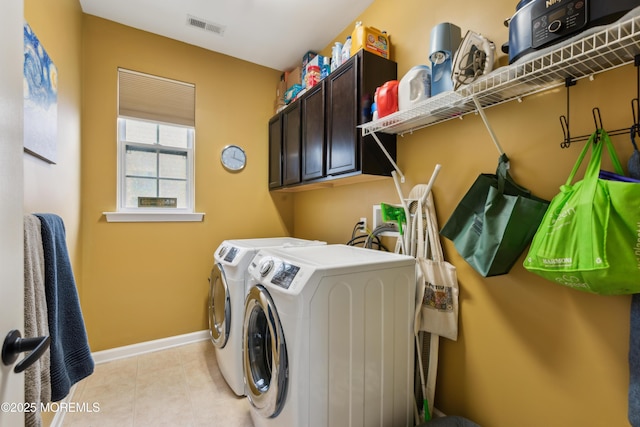 laundry room with cabinets, light tile patterned flooring, and independent washer and dryer