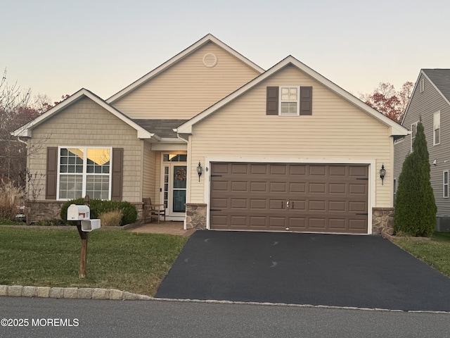 view of front of property with a garage and a lawn