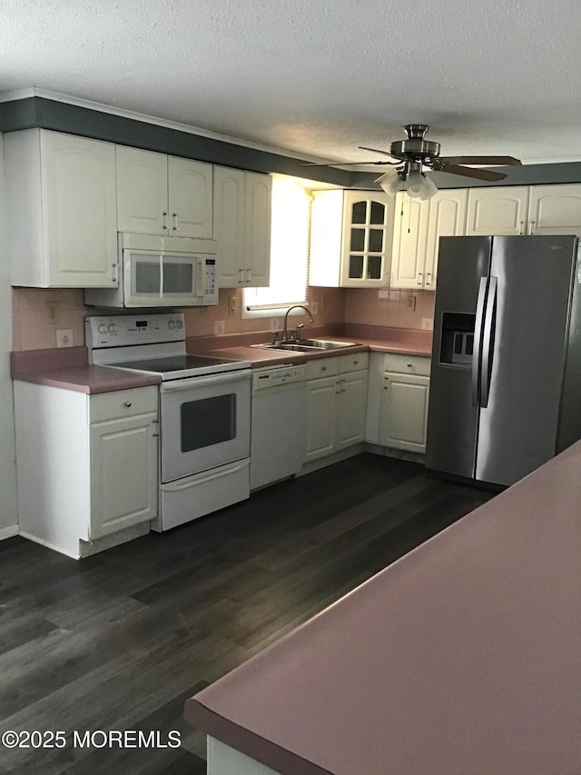 kitchen with dark hardwood / wood-style flooring, white appliances, a textured ceiling, and white cabinets