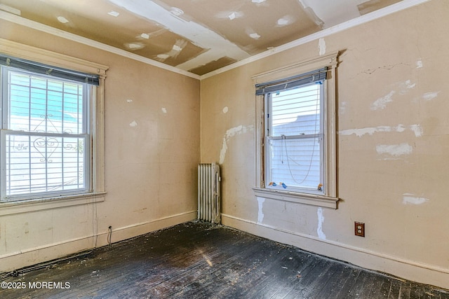 spare room featuring crown molding, radiator heating unit, and dark hardwood / wood-style flooring