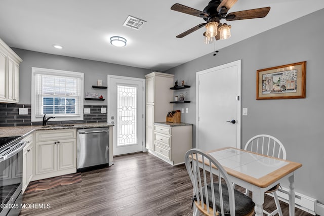 kitchen featuring sink, dark wood-type flooring, appliances with stainless steel finishes, a baseboard heating unit, and backsplash