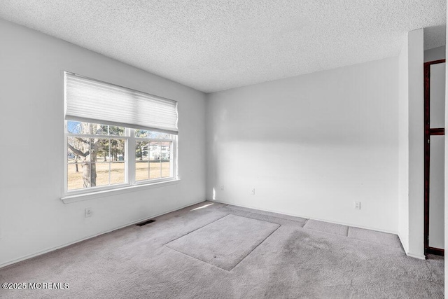 carpeted spare room featuring a textured ceiling