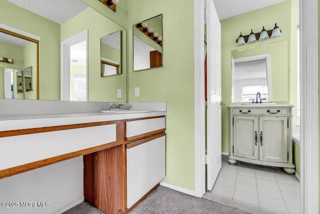 bathroom featuring vanity, tile patterned floors, and a textured ceiling