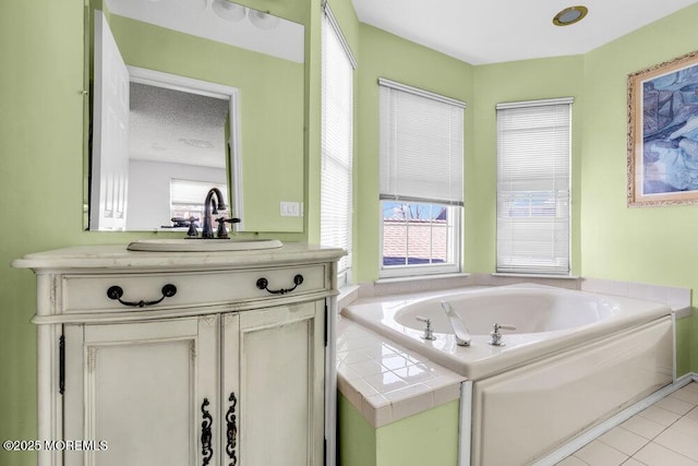 bathroom featuring vanity, tiled tub, a wealth of natural light, and tile patterned floors