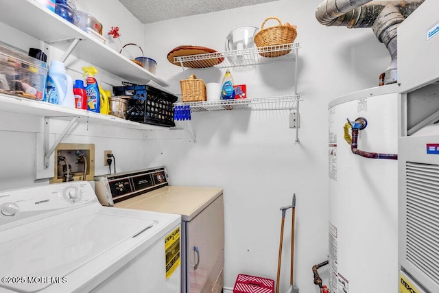 clothes washing area with water heater, washing machine and dryer, and a textured ceiling