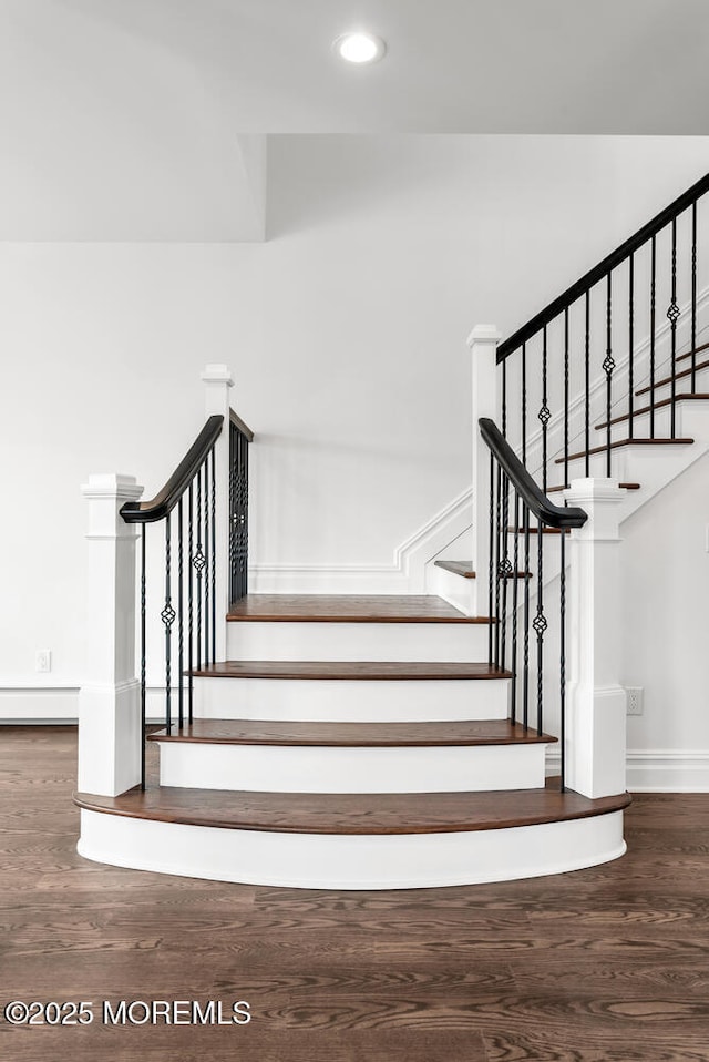 staircase with a baseboard radiator and wood-type flooring