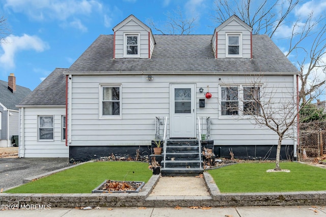 cape cod house with a front lawn