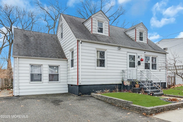 cape cod-style house featuring a front yard