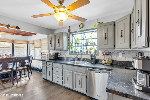 kitchen featuring sink, gray cabinets, stainless steel dishwasher, and hardwood / wood-style floors