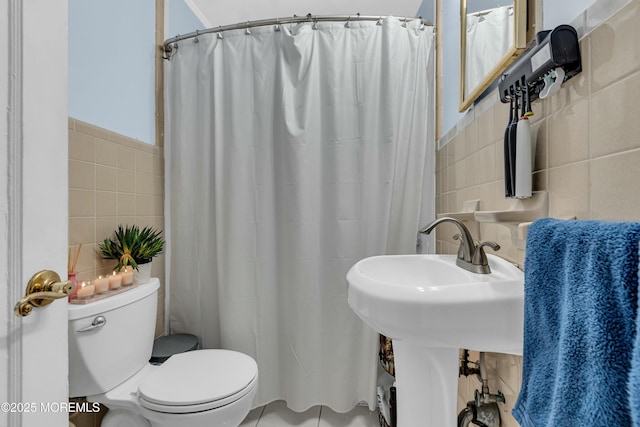 bathroom with tile walls, a shower with shower curtain, and toilet