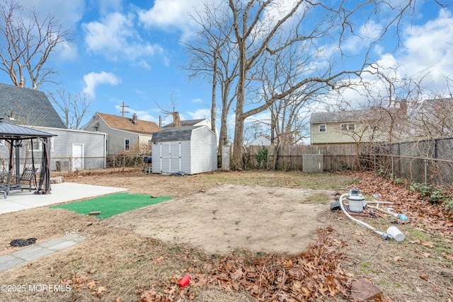 view of yard featuring a patio, a gazebo, and a storage unit