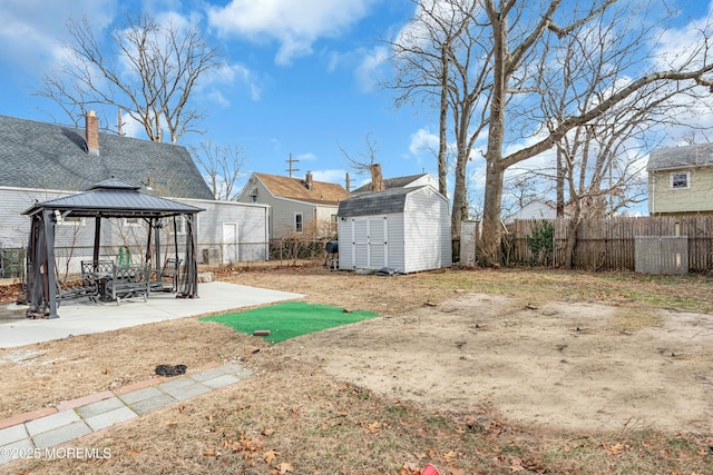 view of yard with a gazebo, a storage shed, and a patio