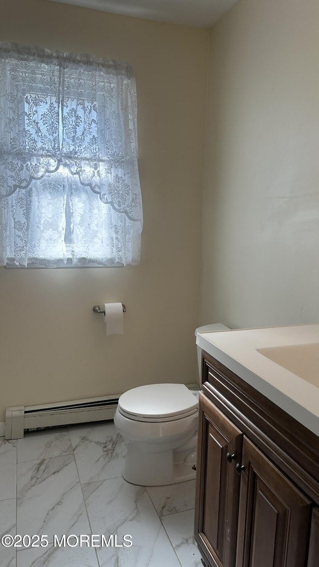 bathroom with vanity, baseboard heating, and toilet