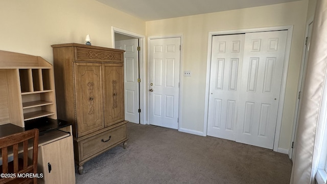 unfurnished bedroom with a closet and dark colored carpet