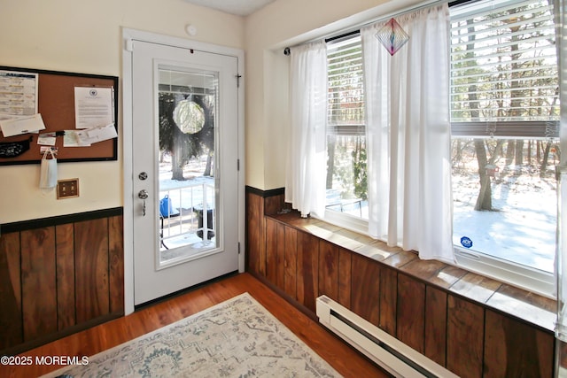 doorway with light hardwood / wood-style floors and a baseboard heating unit