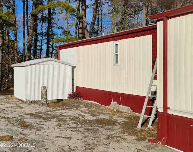 view of side of home featuring a storage shed