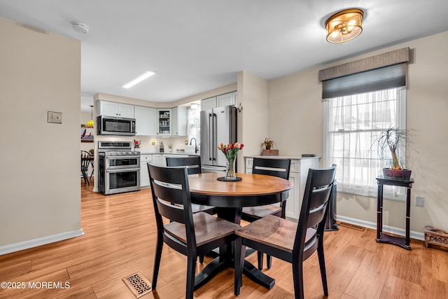 dining room featuring sink and light wood-type flooring