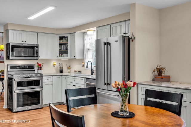 kitchen with stainless steel appliances, sink, and light wood-type flooring