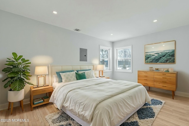 bedroom featuring electric panel and light hardwood / wood-style floors