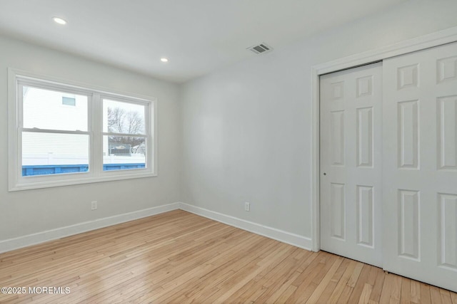 unfurnished bedroom with a closet and light wood-type flooring