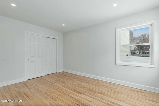 unfurnished bedroom with light hardwood / wood-style floors and a closet