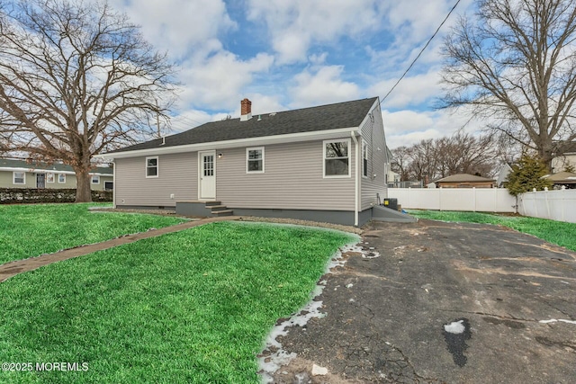 rear view of house featuring a yard