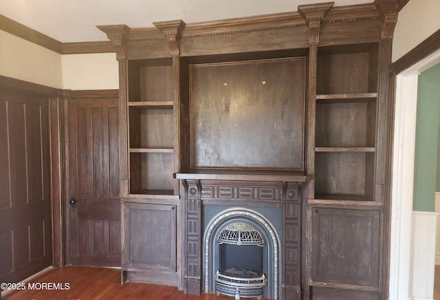 unfurnished living room with built in shelves and wood finished floors