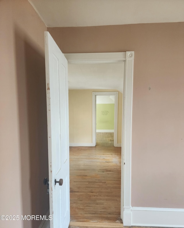 hallway with wood finished floors and baseboards