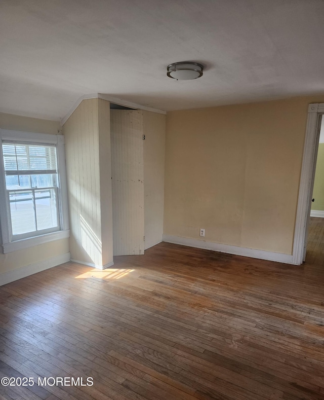 empty room with baseboards and hardwood / wood-style flooring