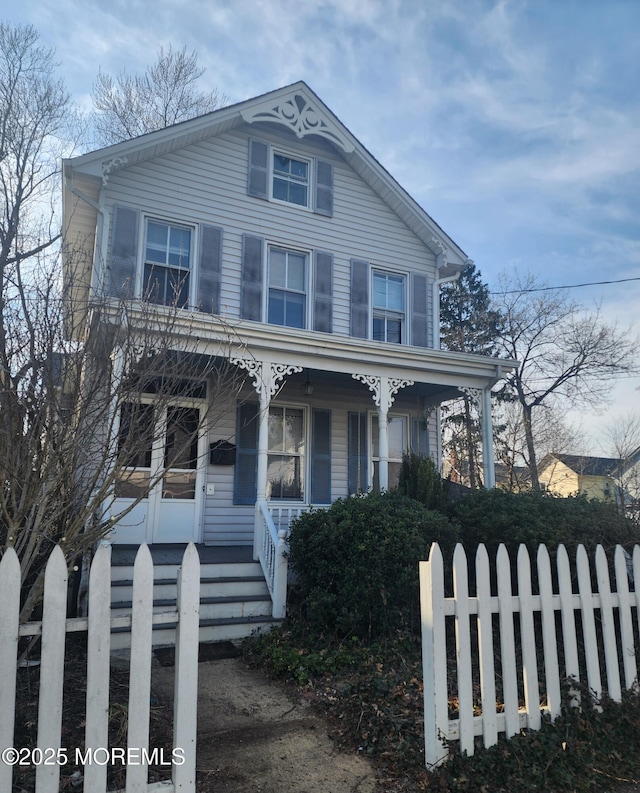 view of front of property featuring a fenced front yard and covered porch