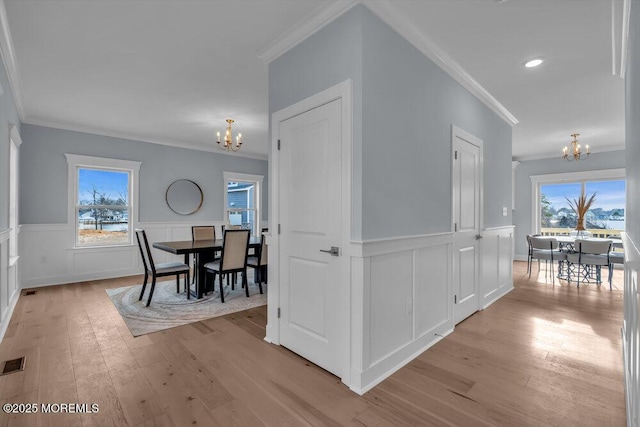 302 Reef Ct, Forked River, NJ 08731 - hall with a chandelier, ornamental molding, light wood-style flooring, wainscoting, and a decorative wall