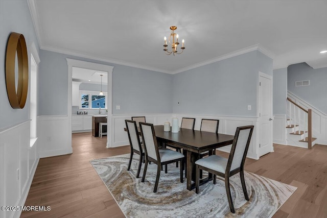 302 Reef Ct, Forked River, NJ 08731 - dining room with a chandelier, wood finished floors, wainscoting, stairs, and crown molding