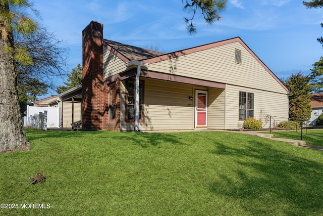 view of front of property featuring a chimney, fence, and a front lawn