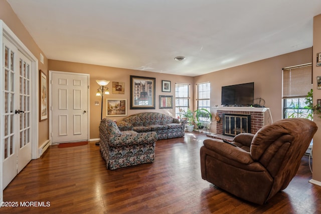 living room featuring a baseboard radiator, dark hardwood / wood-style floors, and a fireplace