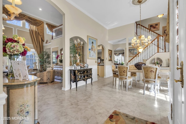 foyer with a towering ceiling and ornamental molding